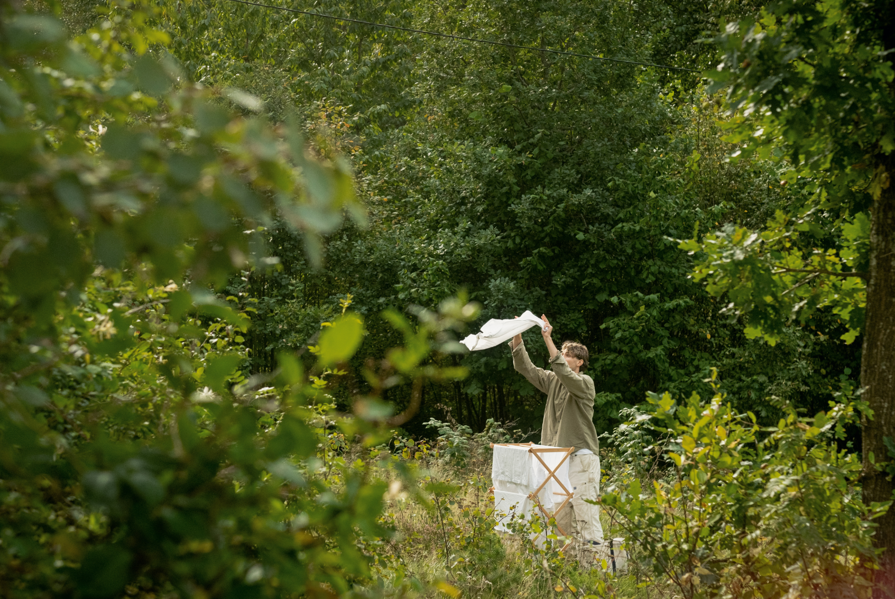 person henger opp klær utendørs med tøyvask fra Concept Zero