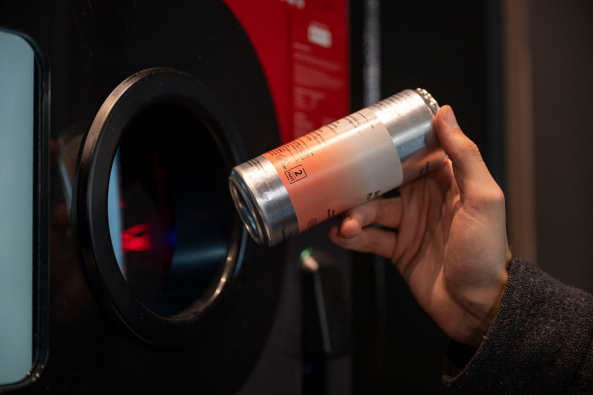 Hånd som panter en tom Concept Zero-boks i en panteautomat